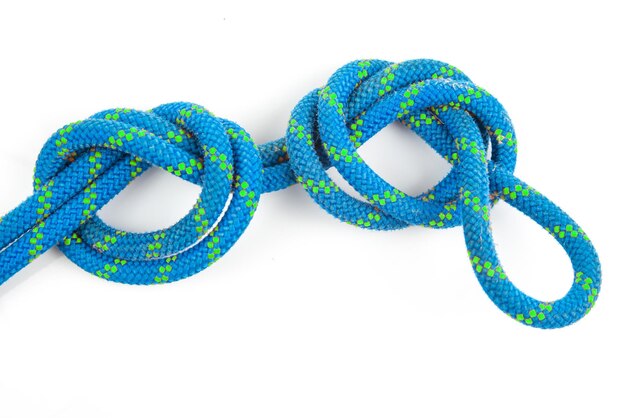 Cuerda de color duradero para equipo de escalada en un nudo de fondo blanco de cable trenzado para turismo y viajes