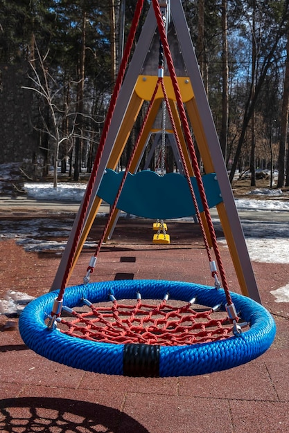 Cuerda coloridos columpios vacíos en el parque infantil en el parque de la ciudad Perspectiva de actividades y entretenimiento para niños