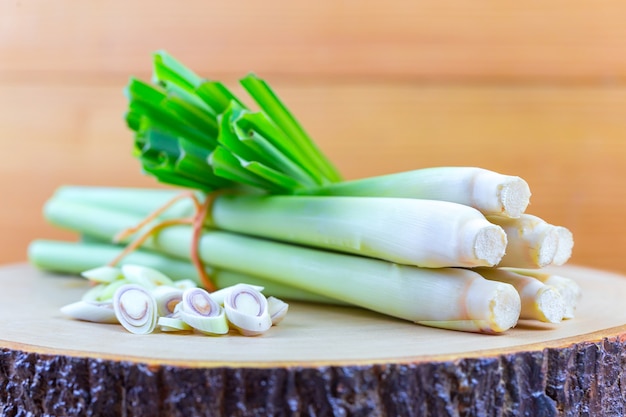 La cuerda y la rodaja de limón frescas del Cymbopogon cortan en tabla de cortar de madera en concepto de cocinar.