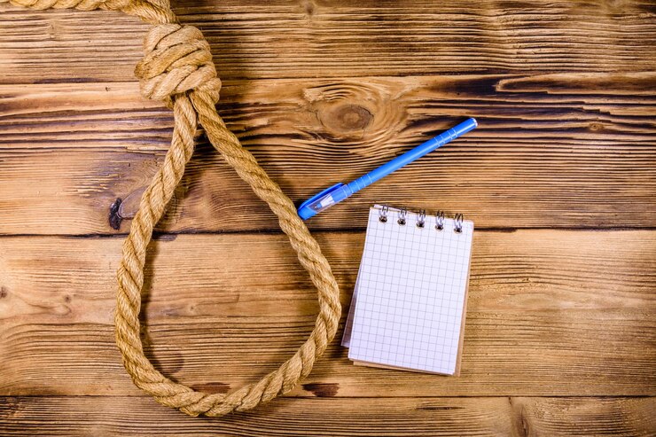 Foto cuerda con soga para el bloc de notas en blanco suicida y bolígrafo sobre fondo de madera