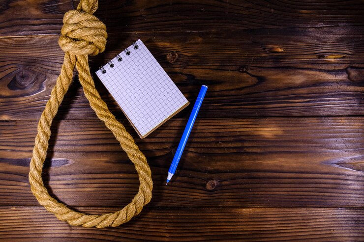 Foto cuerda con soga para el bloc de notas en blanco suicida y bolígrafo sobre fondo de madera