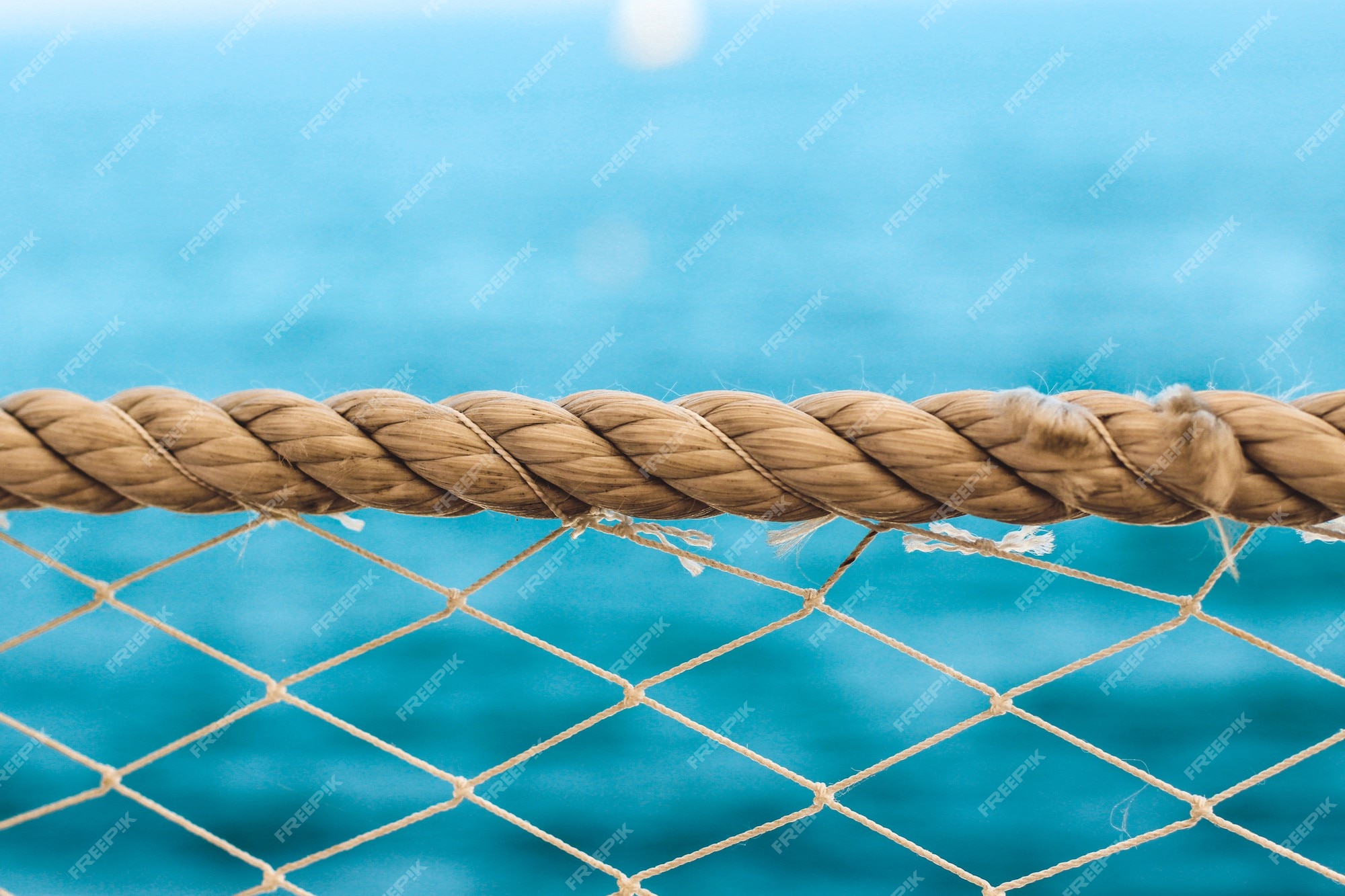 Cuerda de textura náutica y malla con el fondo del agua mar. Foto Premium