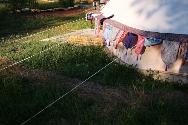 Foto cuerdas de carpa glamping antiguas en el césped de la zona de acampada