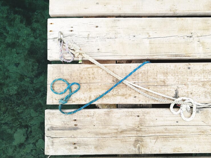 Foto cuerdas cruzadas blancas y azules en un muelle de madera