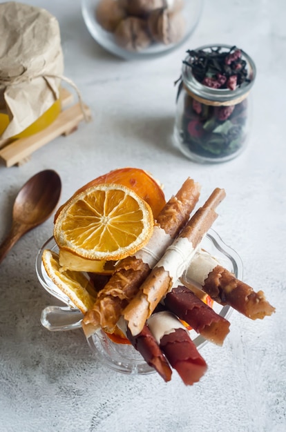 Cuero de frutas variadas caseras y chips secos en placa sobre mesa de madera