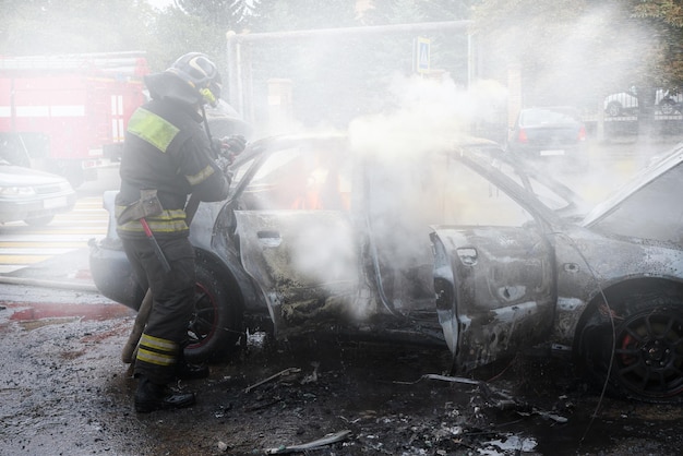 El cuerpo de bomberos extingue un coche en llamas incendio provocado de un coche en la ciudad