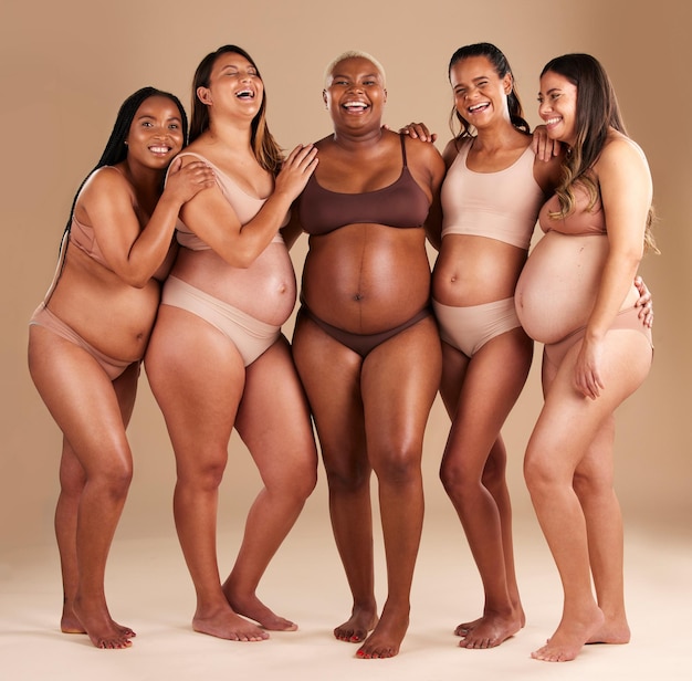 Foto el cuerpo embarazado y el grupo de mujeres que se ríen en diversidad apoyan la solidaridad y la comunidad en el fondo del estudio