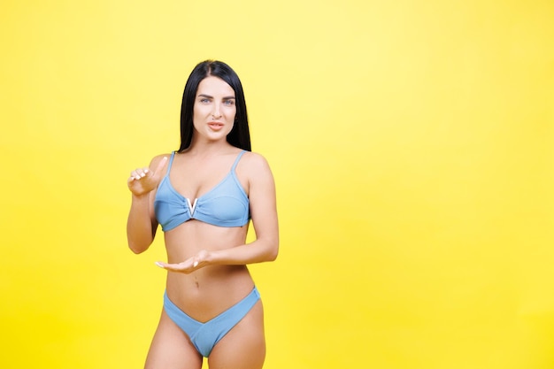 El cuerpo y las manos de la mujer enmarcan el estómago para el cuidado de la piel, la belleza, el bienestar físico o la liposucción modelo en el estudio.