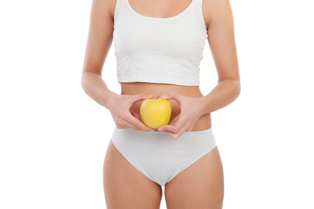 Cuerpo de mujer en ropa interior con una manzana.