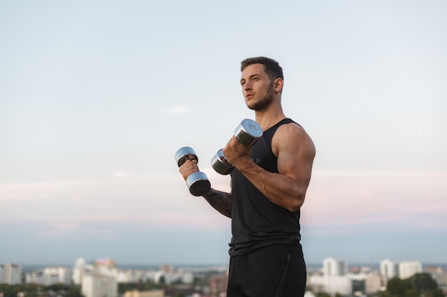 Cuerpo musculoso de atleta masculino haciendo ejercicios en la calle