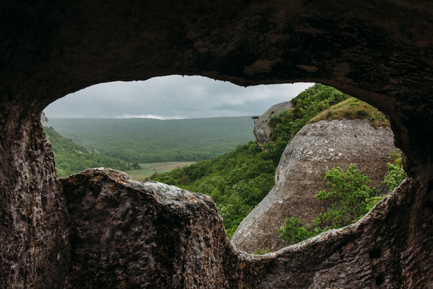 cueva antigua y valle del bosque de montaña verde