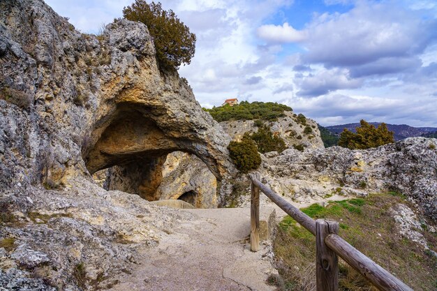 Cueva excavada en la roca con vistas al acantilado de las altas montañas cercanas Ventana del diablo Cuenca