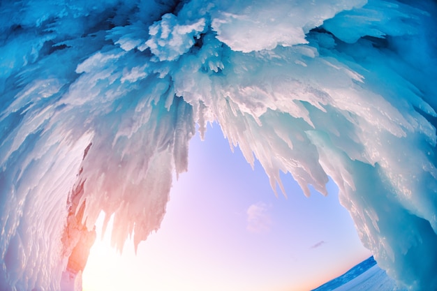 Cueva de hielo en el lago Baikal en invierno. Hielo azul y carámbanos en la luz del sol al atardecer. Isla de Olkhon, Baikal, Siberia, Rusia. Hermoso paisaje de invierno.