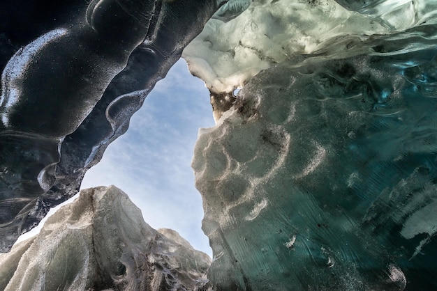 La cueva de hielo ubicada debajo del glaciar entre la montaña de hielo en Islandia es un hito fascinante