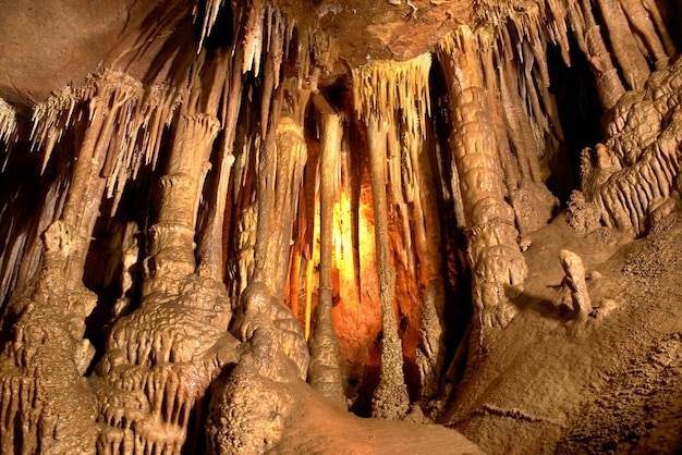 Cueva interior oscuro con luz, estalactitas y estalagmitas.