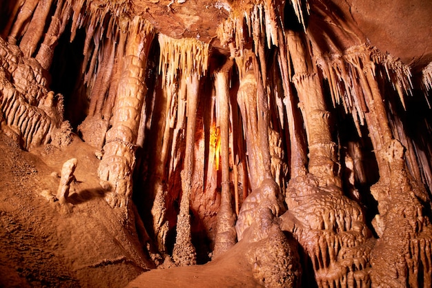 Cueva interior oscuro con luz, estalactitas y estalagmitas.