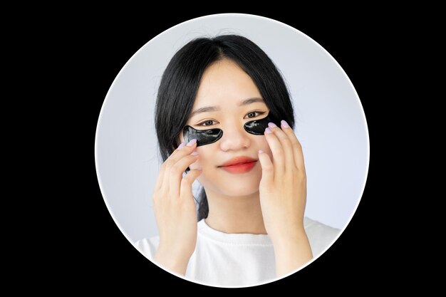 Cuidado de la belleza asiática rejuvenecimiento cosmético tratamiento antienvejecimiento mujer muy sonriente con negro debajo del ojo