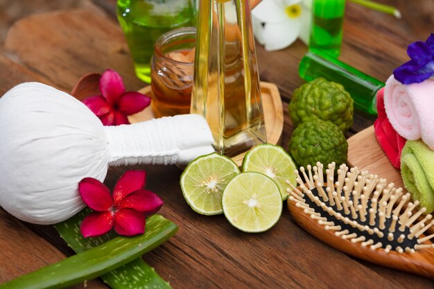 Cuidado del cabello con bergamota y miel, aceite de oliva, toalla, tijeras, peluquero cortado en el piso de madera