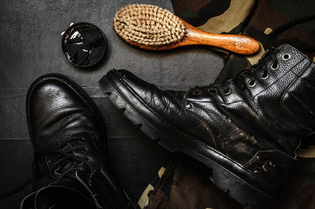 Cuidado del calzado. Zapato de cera, bota y cepillos en superficie de madera. Imagen editada con efecto vintage.