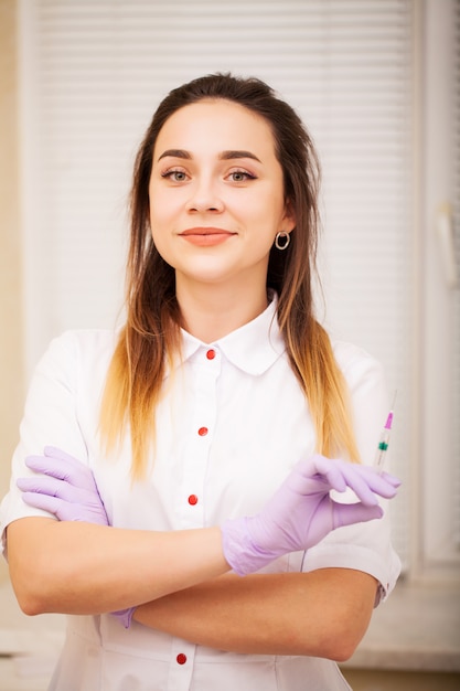 Foto cuidado del cuerpo. doctora que muestra la máquina para depilación láser