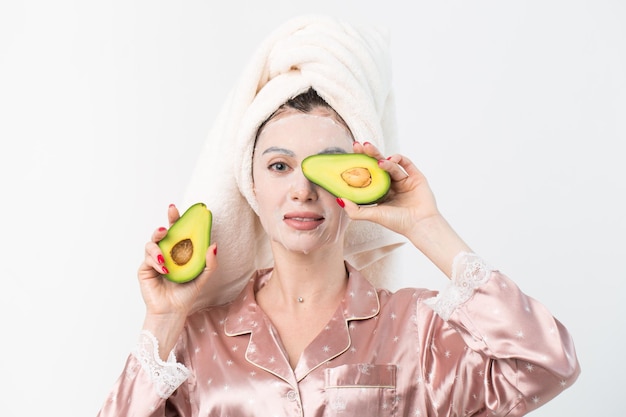 Cuidado facial y tratamientos de belleza Mujer con una mascarilla hidratante de aguacate en la cara aislada de fondo blanco