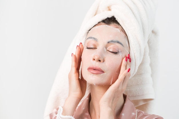 Cuidado facial y tratamientos de belleza Mujer con una mascarilla hidratante en la cara aislada sobre fondo blanco