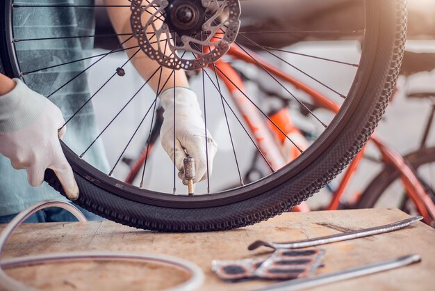 Cuidado de los neumáticos de bicicleta El ciclista está arreglando las ruedas de la bicicleta Primer plano