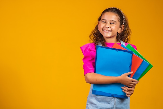 Foto cuidado de niños e infancia feliz, niña bonita con libros listos para el primer día en la escuela.