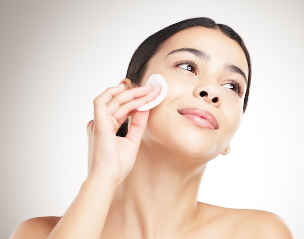 Cuidado de la piel belleza y mujer con almohadilla de algodón para la higiene brillo y exfoliar en fondo de estudio gris lavado facial cosméticos removedor y limpieza maquillaje con producto de tóner para tratamiento de dermatología