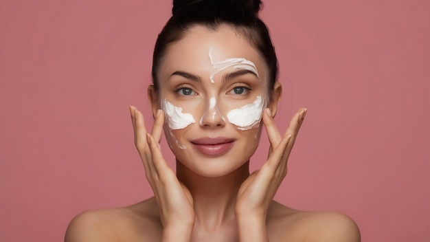 Cuidado de la piel hermosa modelo aplicando tratamiento de crema cosmética en su cara