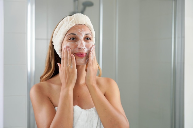 Cuidado de la piel mujer lavando la cara jabón espumoso fregando la piel Lavado de cara exfoliación exfoliación jabón mujer lavando fregando con productos de limpieza para el cuidado de la piel Disfrutando de un momento relajante