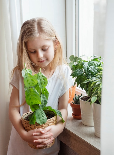 Cuidado de plantas de interior, niña cuidando plantas de interior