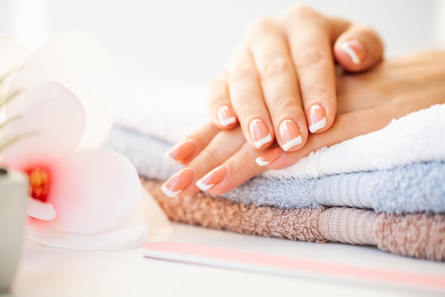 Cuidado de las uñas. Hermosas uñas de mujer con manicura francesa