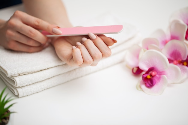 Cuidado de las uñas, mujer con hermosas manos haciendo manicura en estudio de belleza