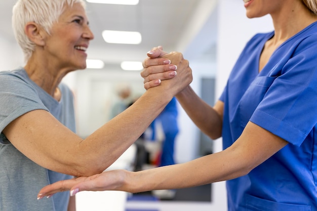 Cuidador ajudando mulher idosa satisfeita a se exercitar na clínica Reabilitação para cuidados médicos idosos Mulher idosa retornando ao bom estado de saúde