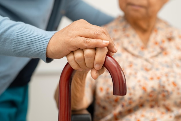 El cuidador ayuda a una anciana asiática a paciente con cuidado amoroso, aliento y empatía