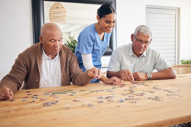 Cuidador de jogo de quebra-cabeça e homens idosos jogando para entretenimento ou se unindo em uma casa de repouso Diversão feliz e idosos desfrutam de reabilitação mental e desenvolvimento com enfermeira
