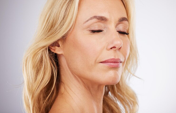 Foto cuidados com a pele de beleza e rosto de uma mulher em estúdio para cosméticos e dermatologia antienvelhecimento pessoa modelo estética em fundo cinza para cuidados de amor próprio e brilho e brilho facial saudável ou de bem-estar