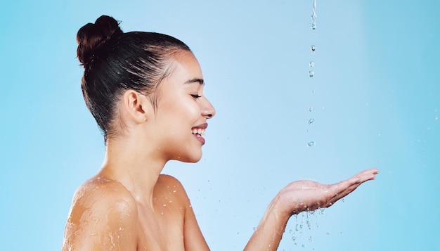 Cuidados com a pele de gotas de água e mulher com maquete para saúde, bem-estar e higiene isolados no fundo azul do estúdio Dermatologia de banho e modelo de brilho de beleza cosmética no tratamento ou rotina de cuidados com a pele