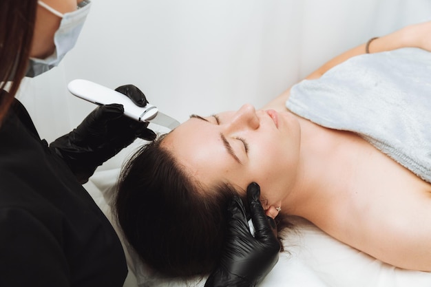 Cuidados com a pele Detalhe de uma linda mulher recebendo um peeling facial ultrassônico Procedimento ultrassônico de limpeza da pele Procedimentos cosméticos Cosmetologia