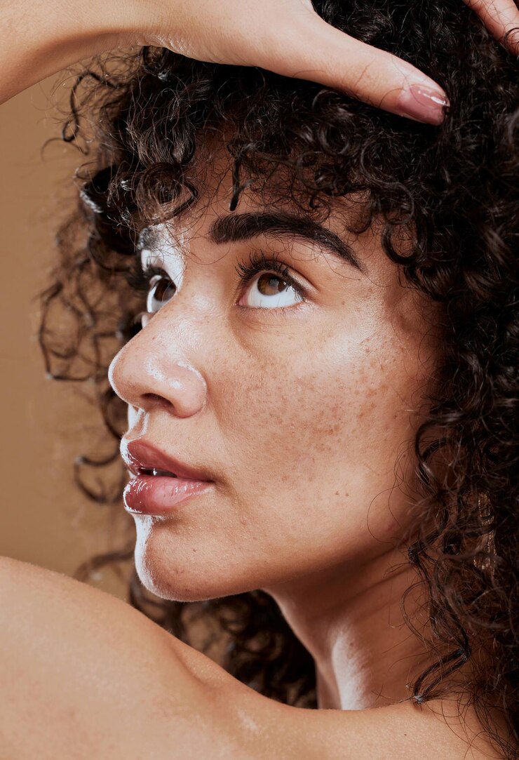 Foto cuidados com a pele e cabelos naturais de uma jovem em estúdio para maquiagem cosmética e cuidados com os cabelos para saúde e bem-estar brilho facial de uma mulher após tratamento facial com creme dermatológico para pele com acne