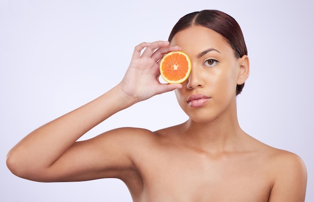 Cuidados com a pele laranja e retrato de mulher em estúdio para tratamento de vitamina c e cosméticos em fundo roxo Modelo de rosto de frutas e meninas relaxa com desintoxicação facial ou de pele diy com limpeza cítrica