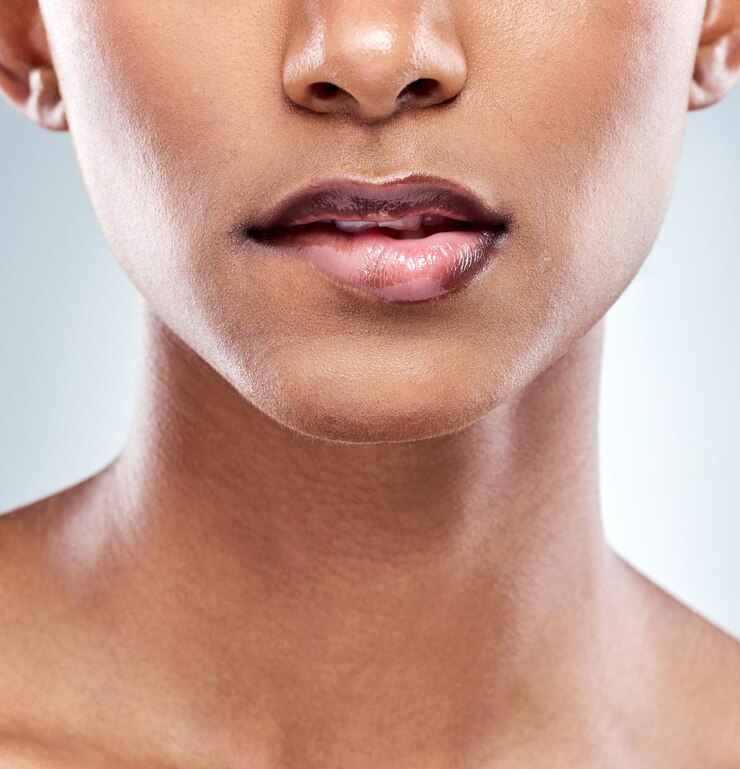 Foto cuidados com a pele mulher e rosto mordendo lábio em close-up para beleza e dermatologia isolado em estúdio boca pessoa feminina ou modelo e tratamento de spa de luxo para cosméticos e maquiagem com fundo branco