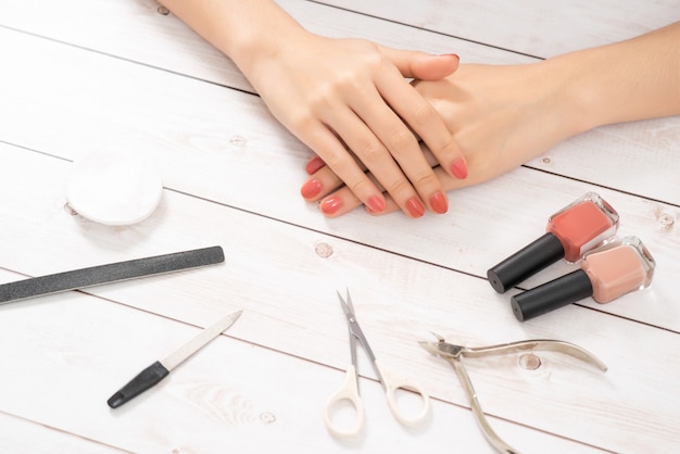 Cuidados com as unhas e manicure. Lindas mãos femininas com esmalte rosa