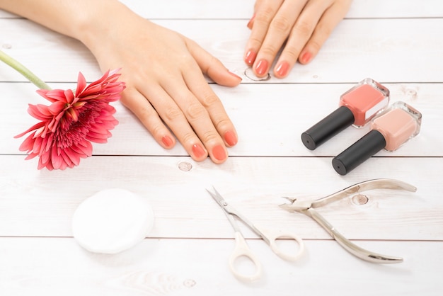 Cuidados com as unhas e manicure. Lindas mãos femininas com esmalte rosa