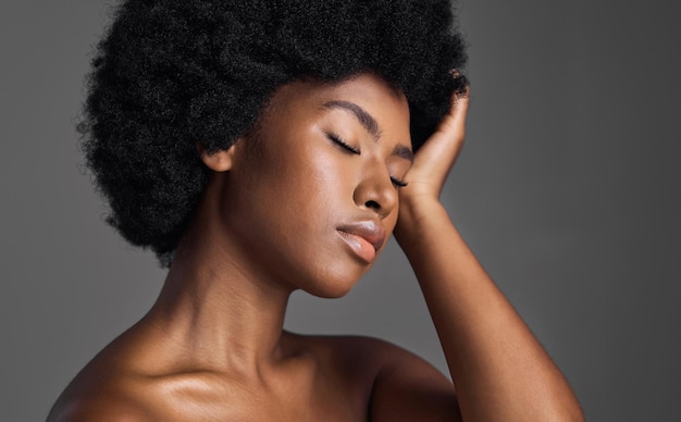 Cuidados com o cabelo de beleza natural e mulher negra com dermatologia para a pele e garota confiante em um fundo de estúdio cinza Luxo ou modelo de pessoa do sexo feminino com cosméticos de maquiagem e estética com cuidados