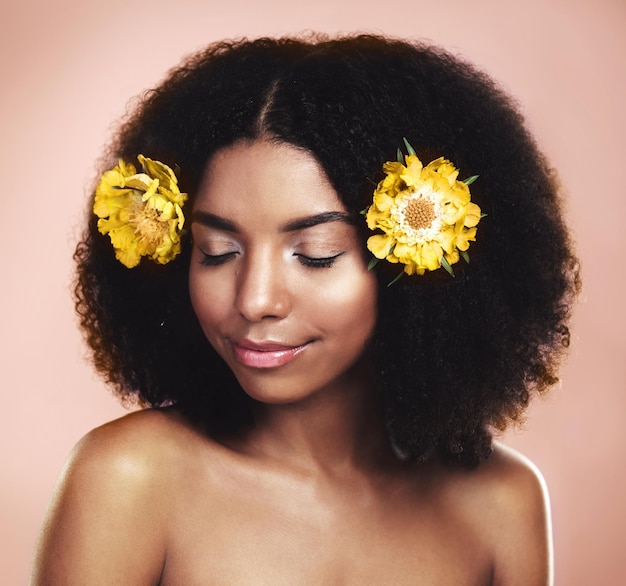 Cuidados com o cabelo feminino e flores amarelas em fundo de estúdio para estética floral de beleza natural ou brilho Rosto de cuidados com a pele de modelo africano e margaridas em afro para cosméticos de sustentabilidade e brilho