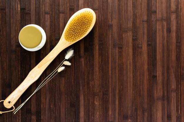 Cuidados com o corpo anticelulite Em uma mesa de madeira escura, um pote de creme, uma escova de massagem e flores secas O conceito de tratamento cosmético de cuidados com a pele preservação da juventude