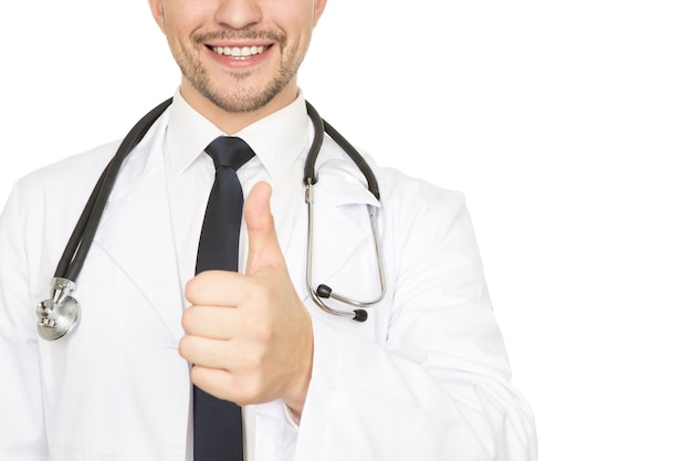 Cuidados de saúde de alto nível. Close recortado de um médico sorrindo alegremente, mostrando os polegares isolados no branco