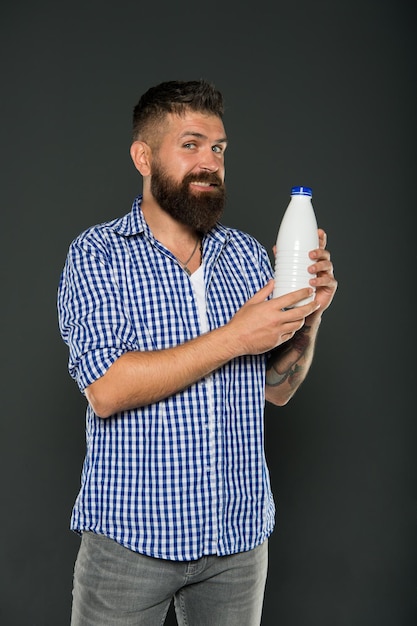 Cuidados de saúde e dieta Produtos lácteos Consumir lactose Nutrição saudável Iogurte probióticos e prebióticos Homem barbudo segura garrafa branca com leite Beber leite brutal caucasiano hipster Dieta à base de lactose